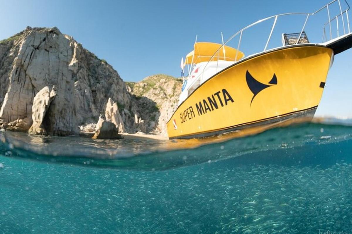 un bateau jaune dans l'eau à côté d'un rocher