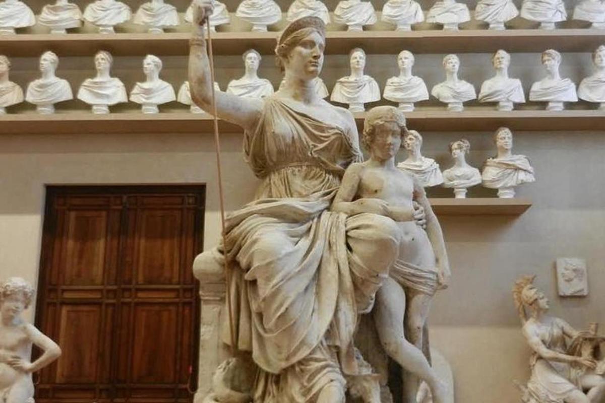 uma estátua de uma mulher com uma criança em um poste