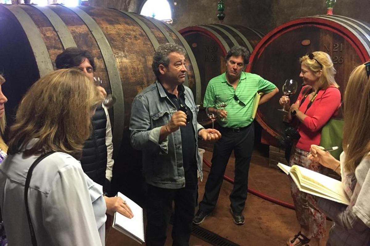 un gruppo di persone in piedi in una cantina vinicola