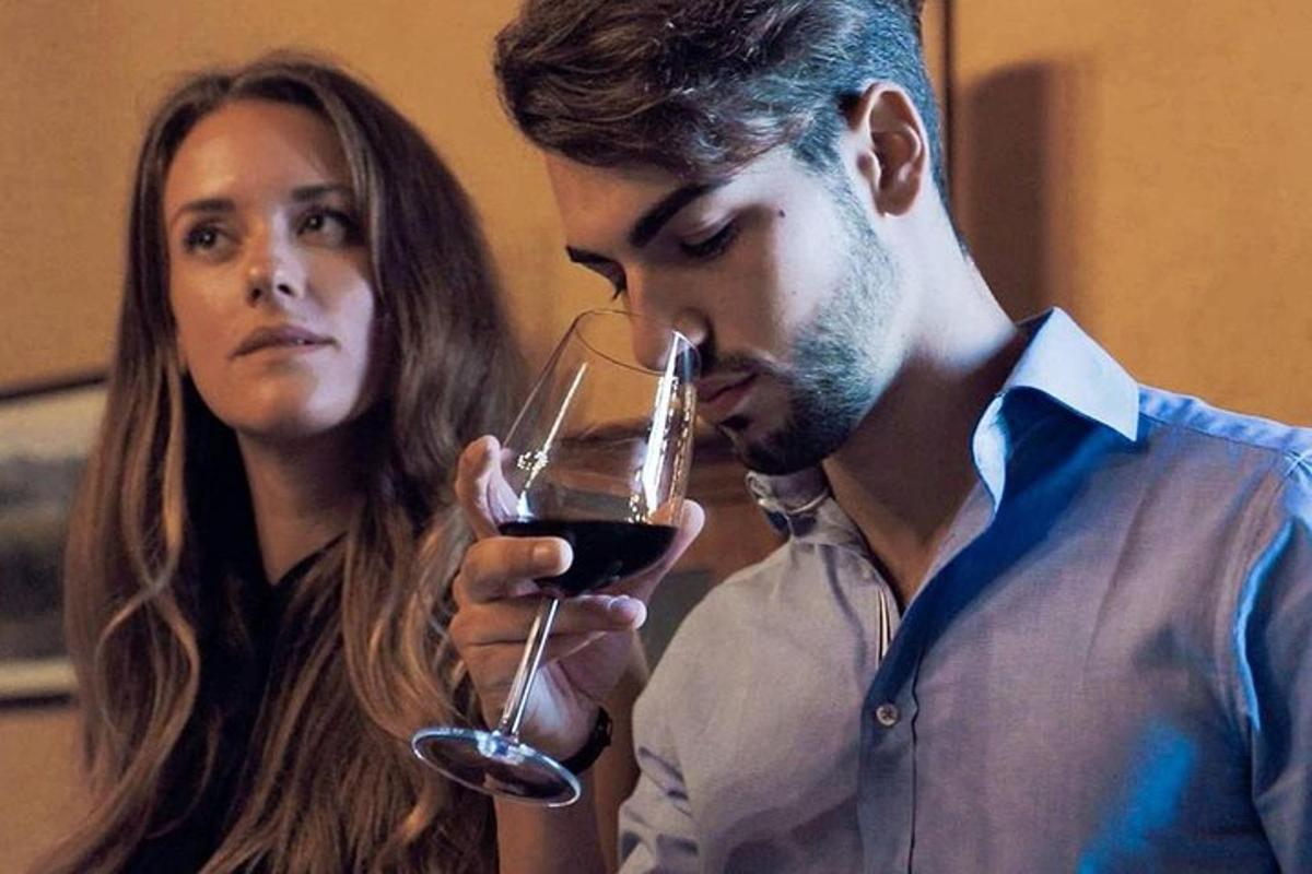 un uomo e una donna che bevono un bicchiere di vino