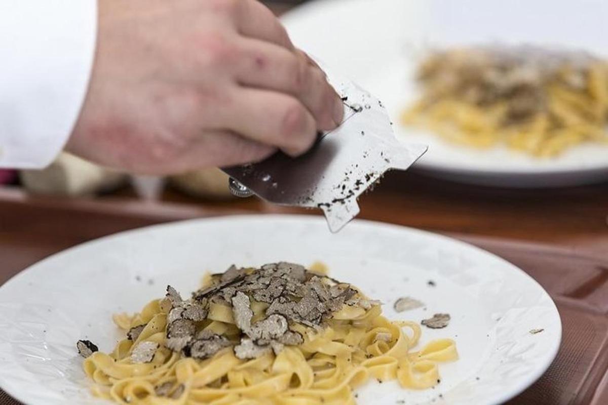 una persona sta mangiando pasta su un piatto bianco