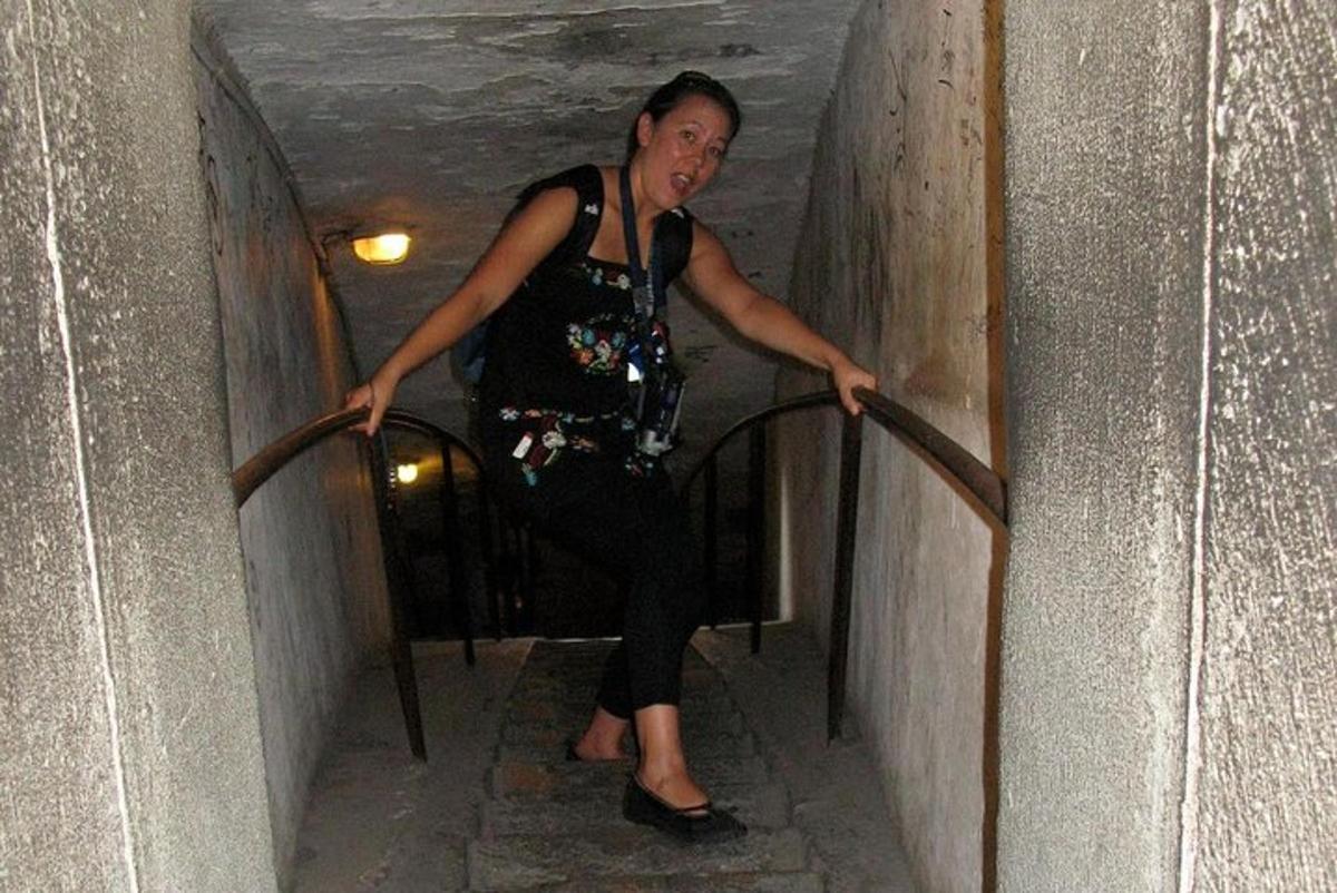 μια γυναίκα που στέκεται σε ένα κιγκλίδωμα σε μια σήραγγα