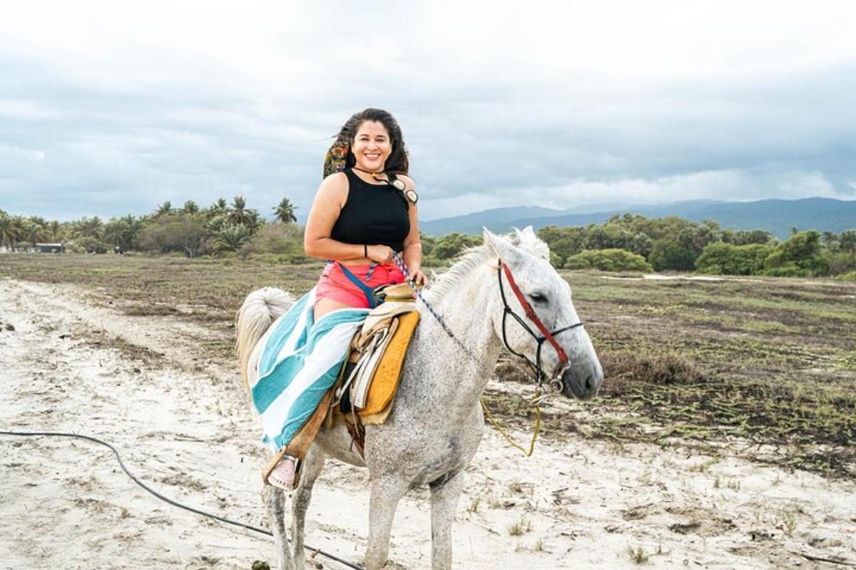 una mujer montando a caballo en la playa