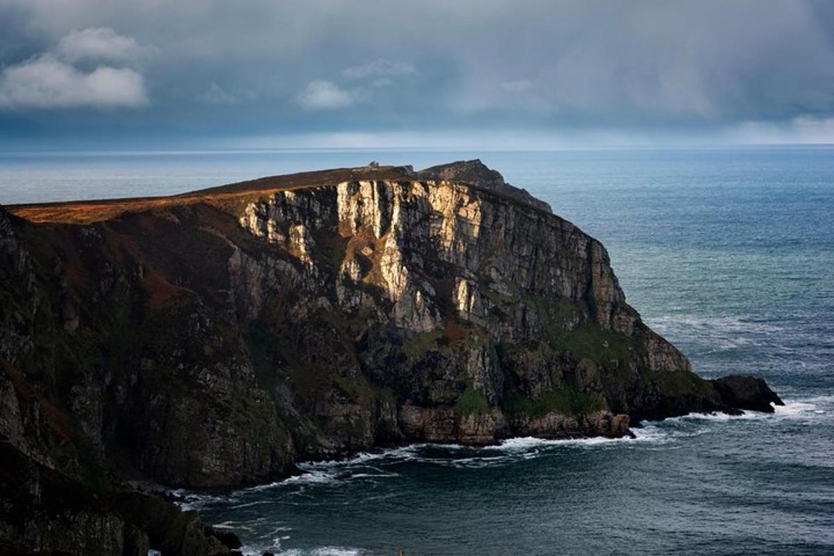 a large cliff sticking out of the ocean
