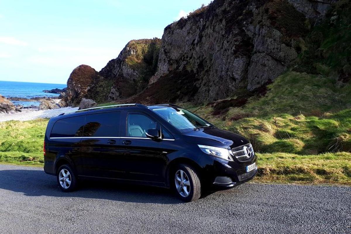 a black suv parked on the side of a beach