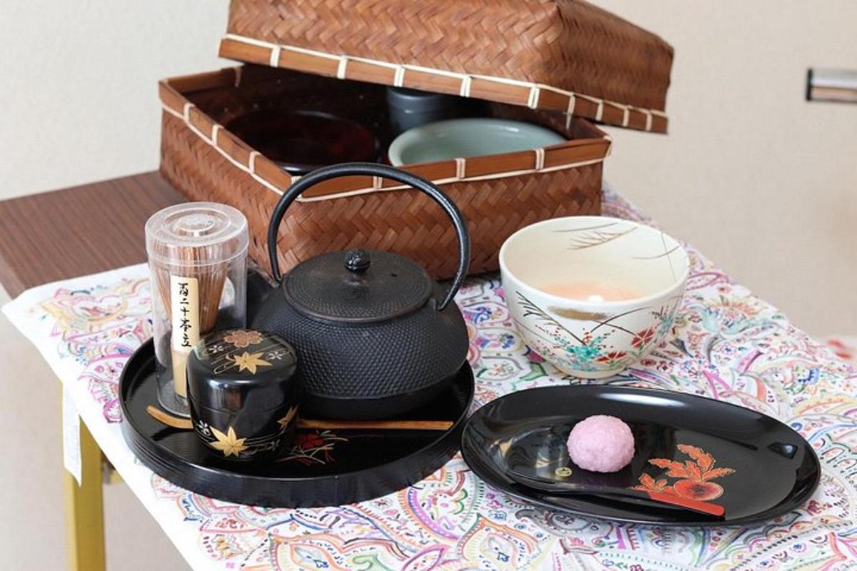 uma mesa com um bule de chá e uma cesta de pratos