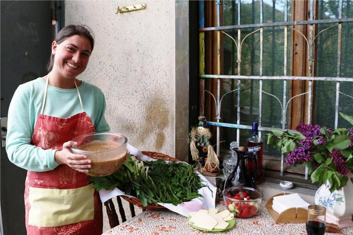 o femeie care stă în bucătărie ținând în mână un bol cu verdețuri