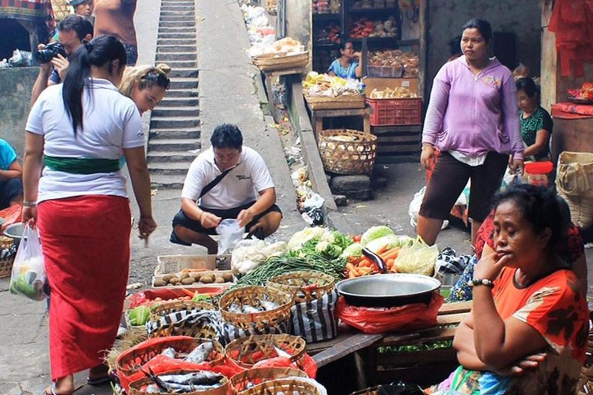 un gruppo di persone in piedi intorno a un mercato con le verdure