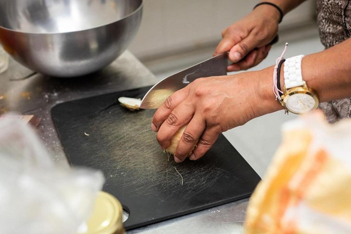 egy személy, aki kést tart a vágódeszkán