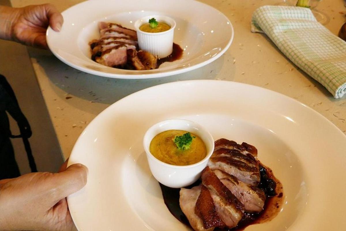 una persona che tiene in mano un piatto di carne e una ciotola di zuppa