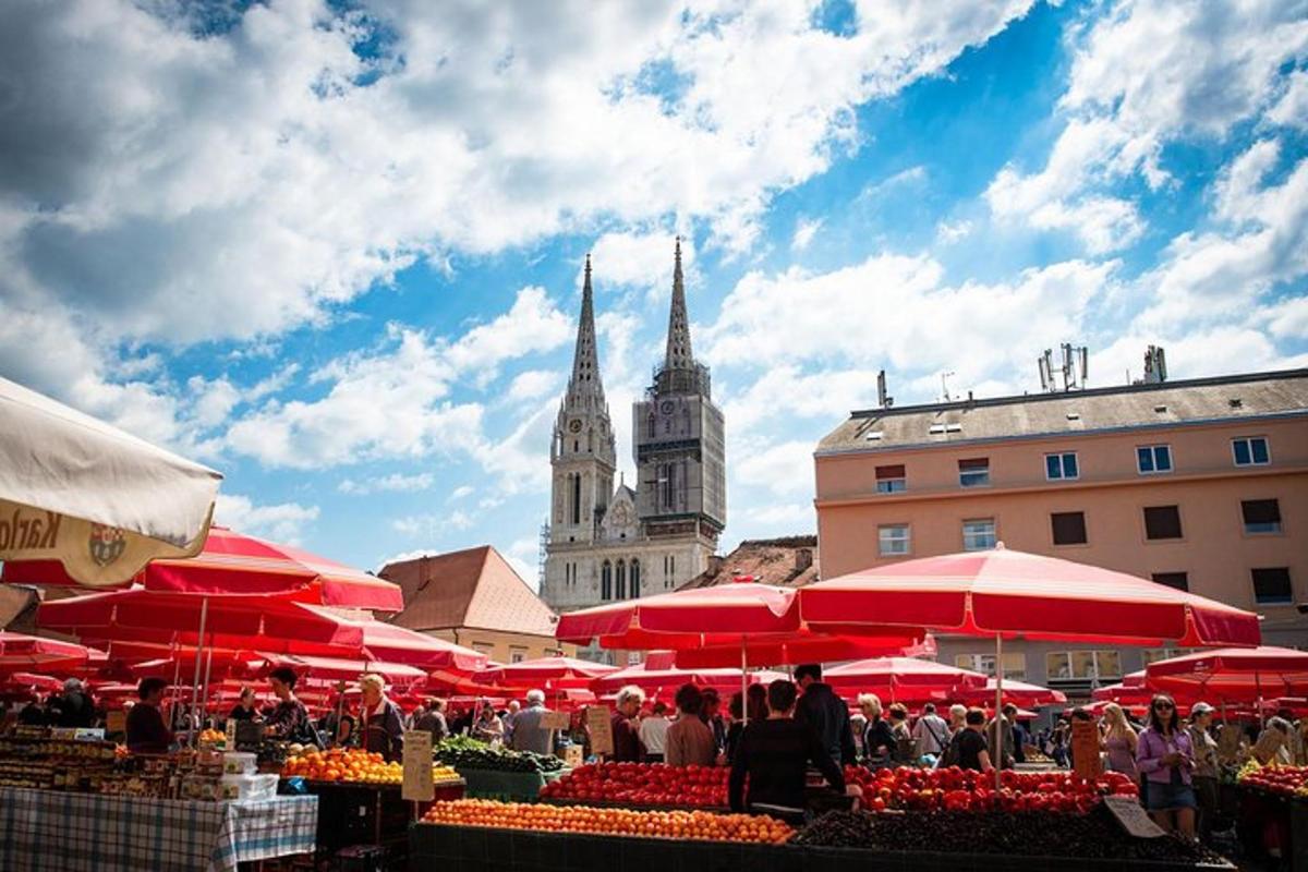 a market with red umbrellas in front of a building