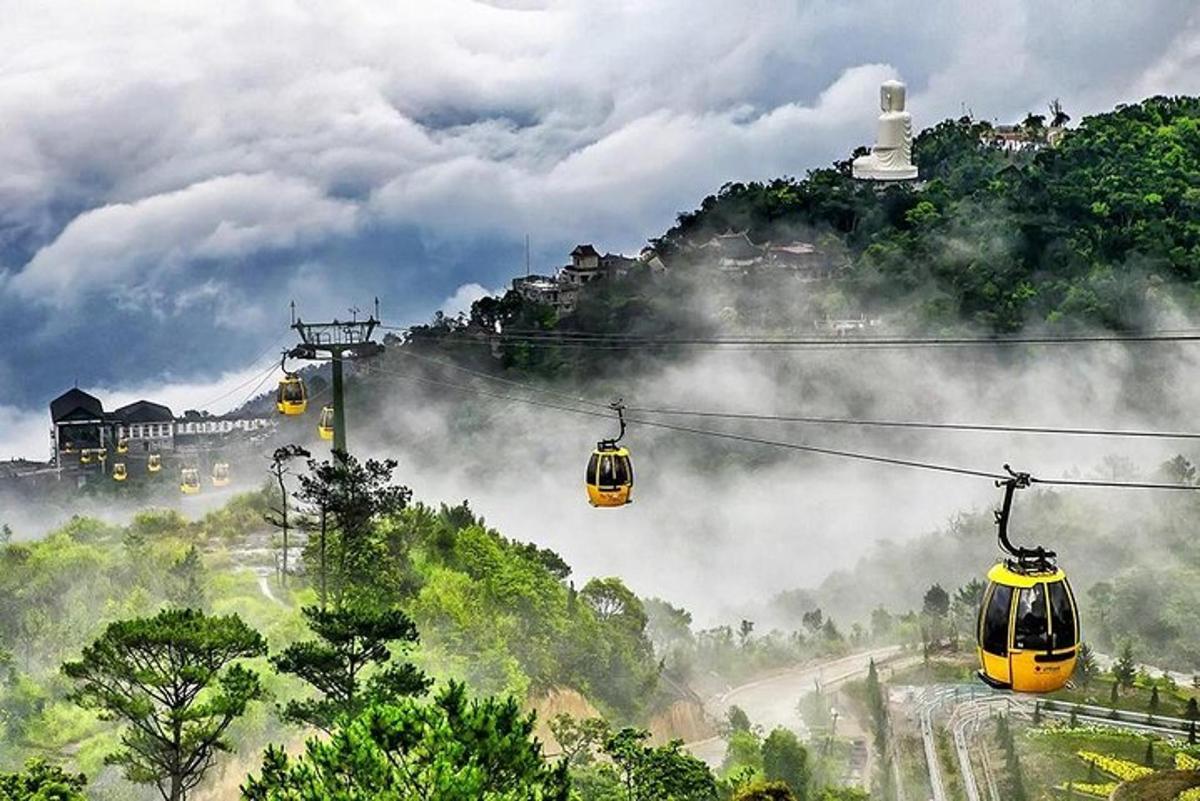 hai chiếc cáp treo màu vàng trên một ngọn đồi có núi