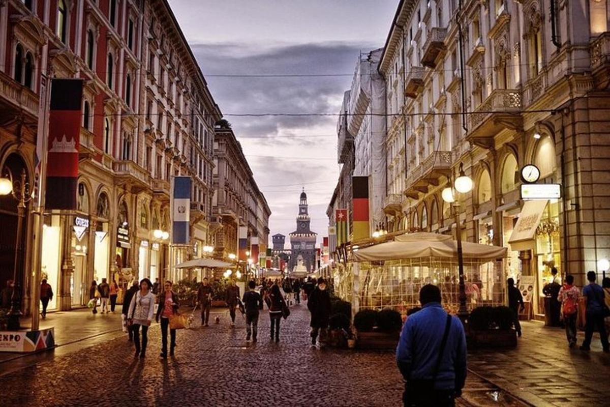 un gruppo di persone che camminano lungo una strada con edifici