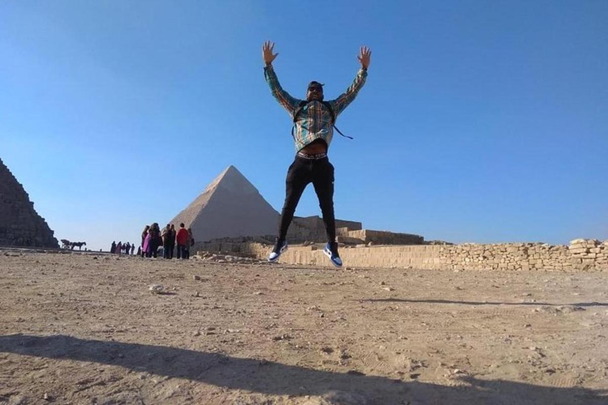 muž skákající do vzduchu před pyramidami