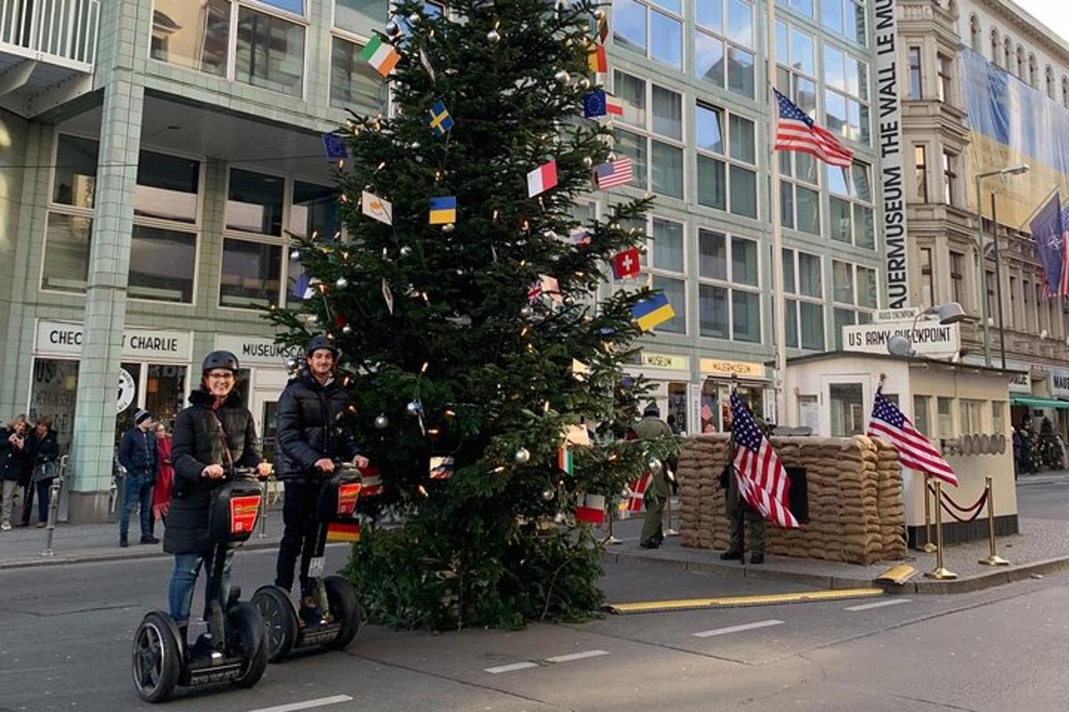 due persone in segway davanti a un albero di Natale