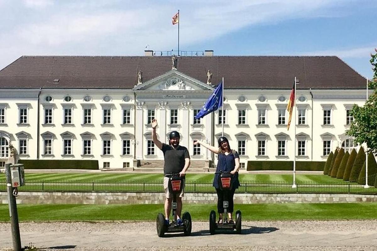 un uomo e una donna in segway davanti a un edificio bianco