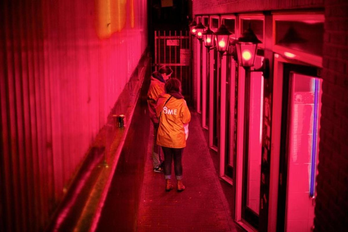 een groep mensen die door een gang met rode lichten loopt