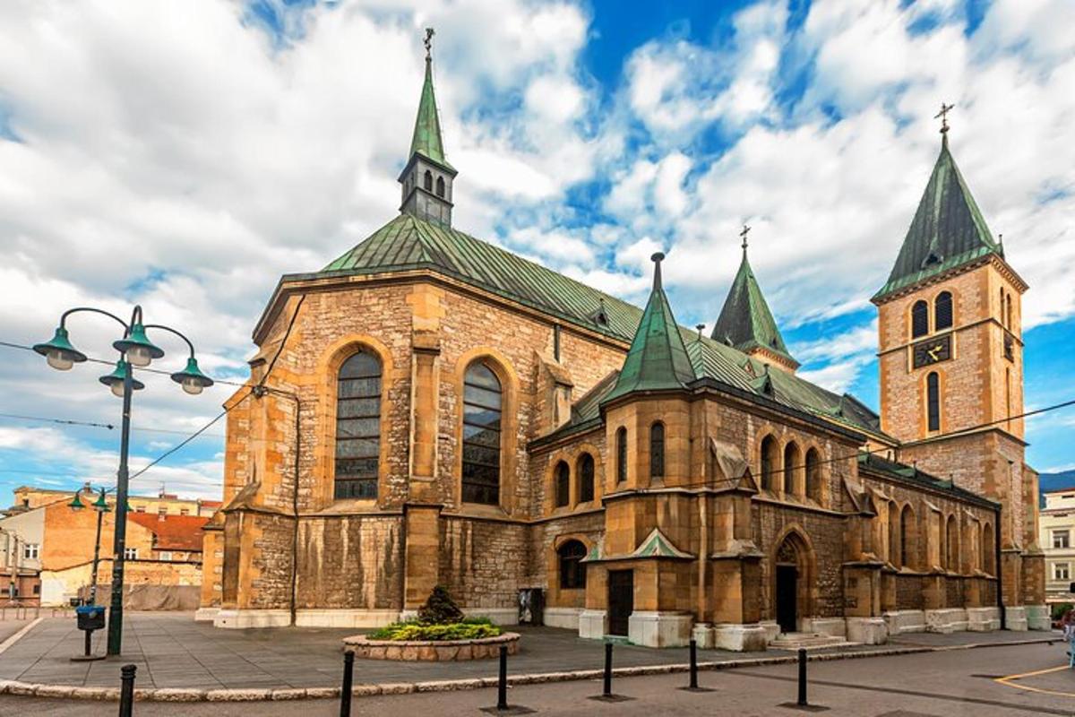 a large stone church with green towers on a street