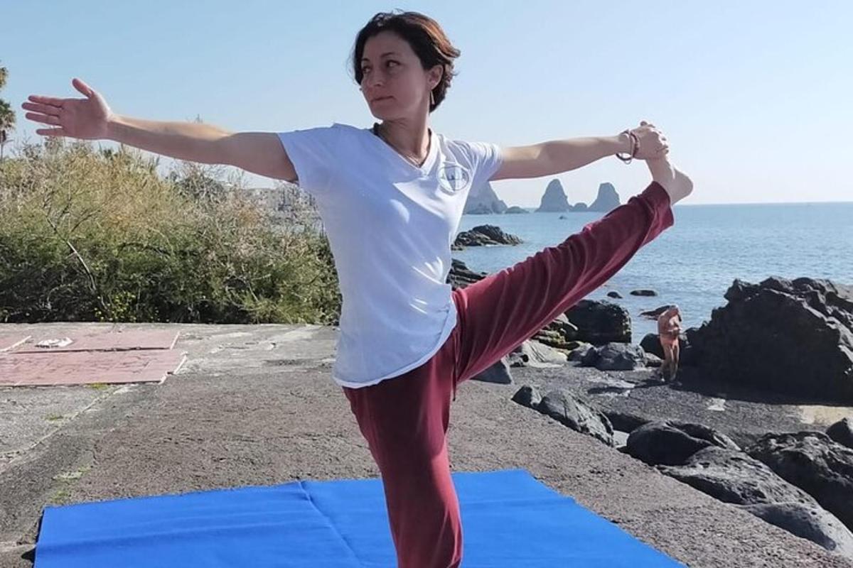seorang wanita melakukan pose yoga di pantai