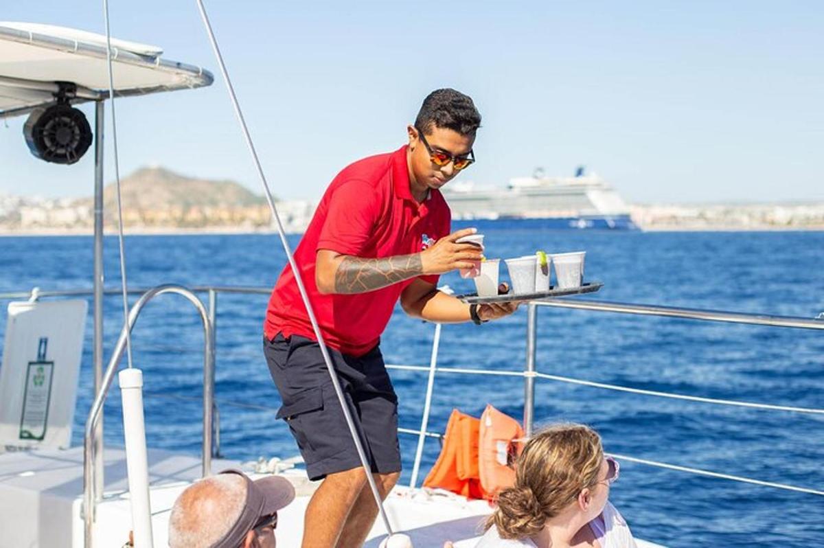 Un hombre de pie en un barco con una bandeja de bebidas.