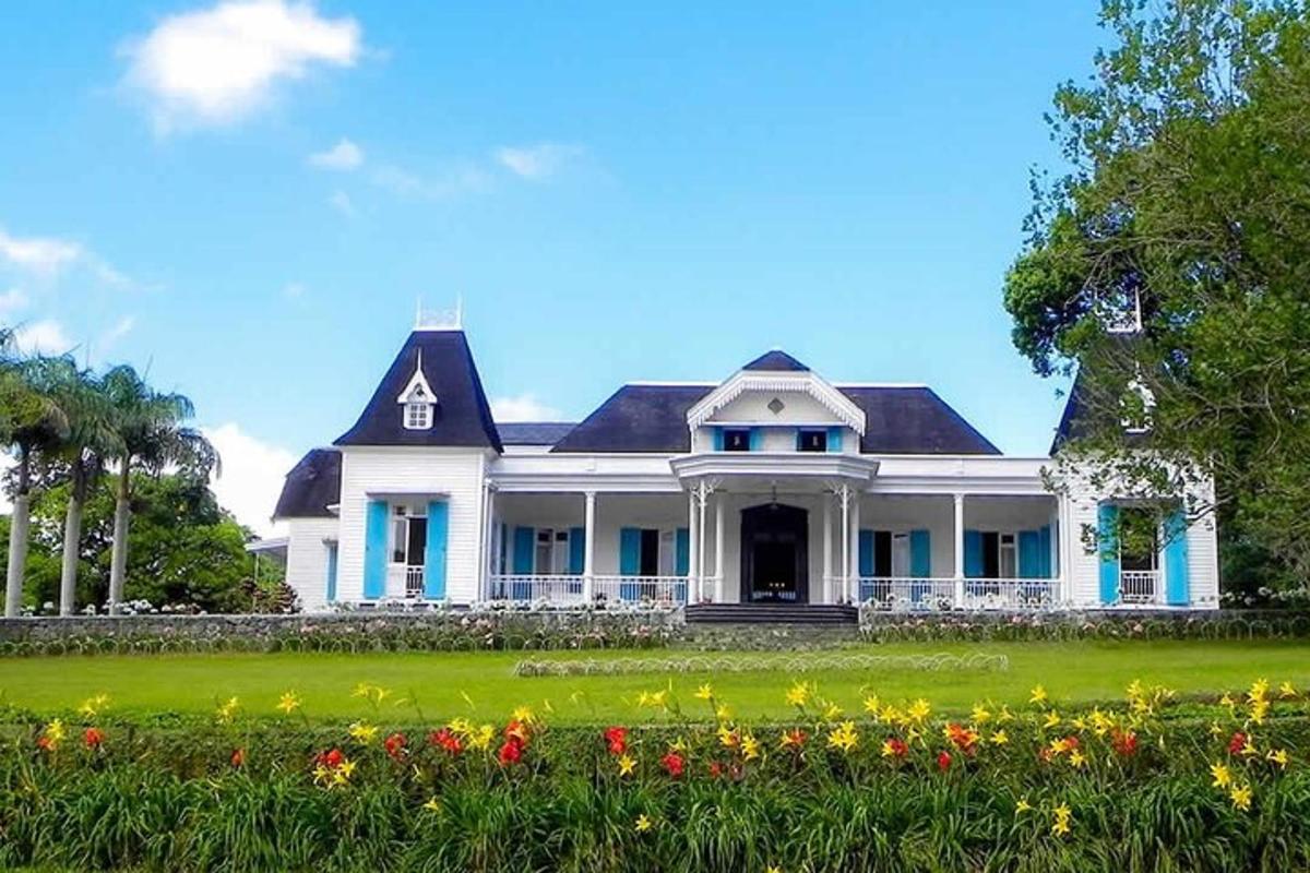 una grande casa bianca con dei fiori davanti