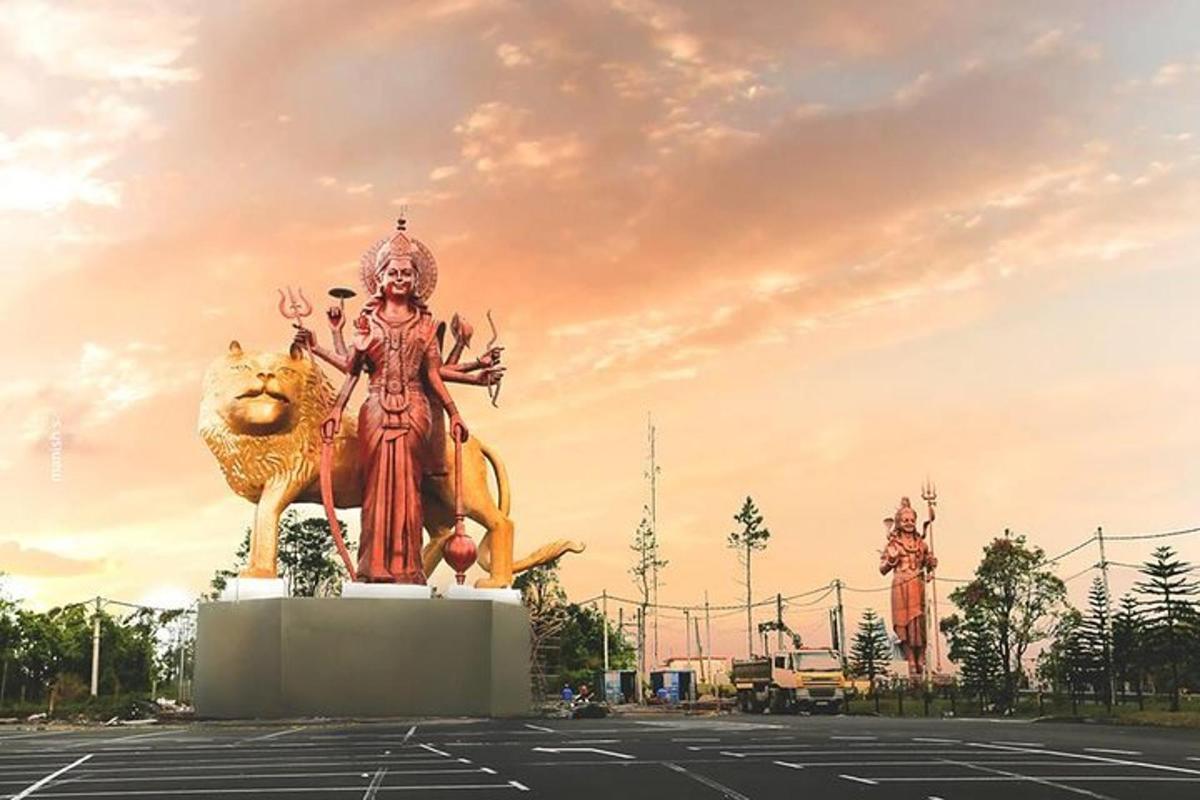 a large statue of a goddess standing in a parking lot