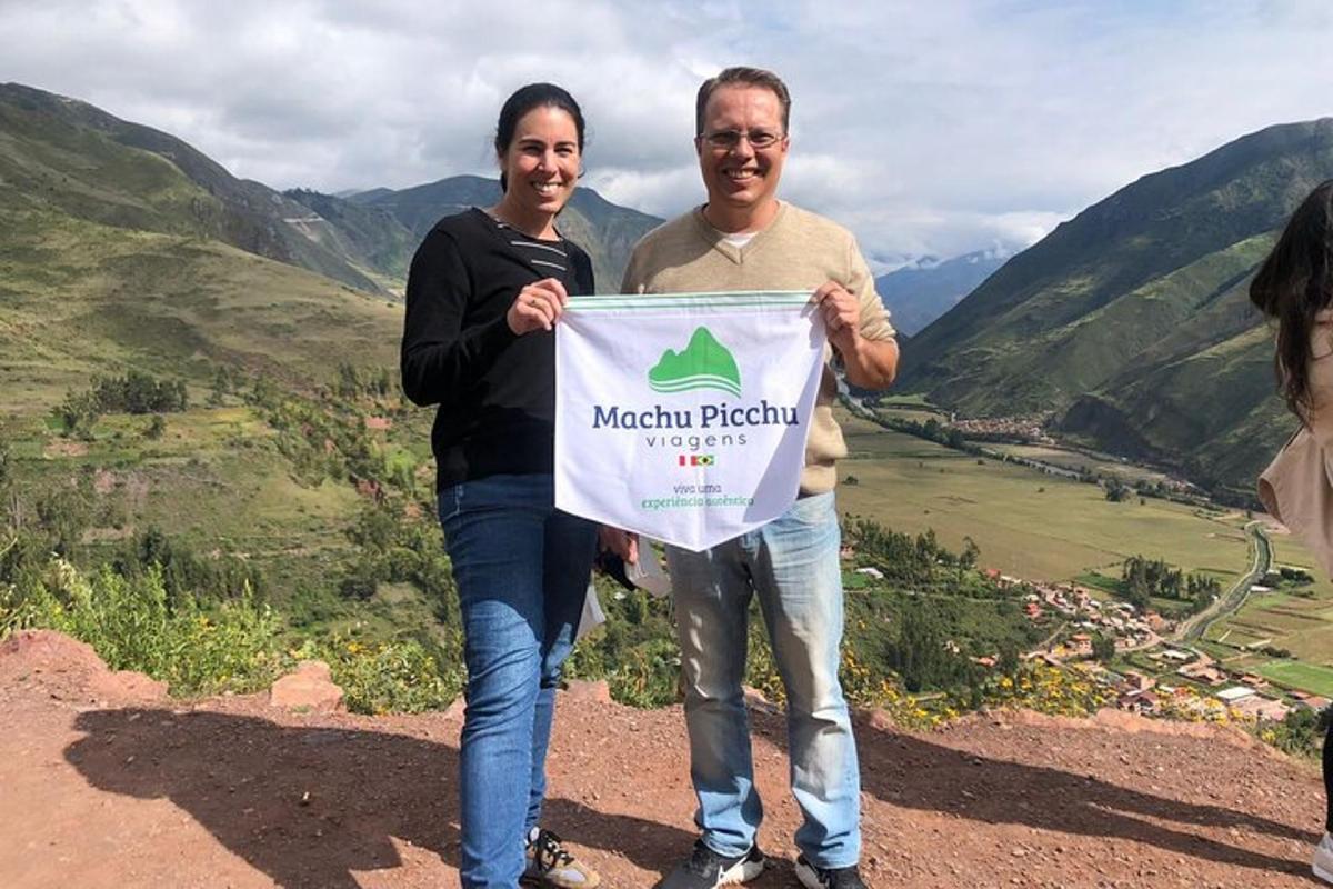muž a žena držící ceduli na vrcholu hory