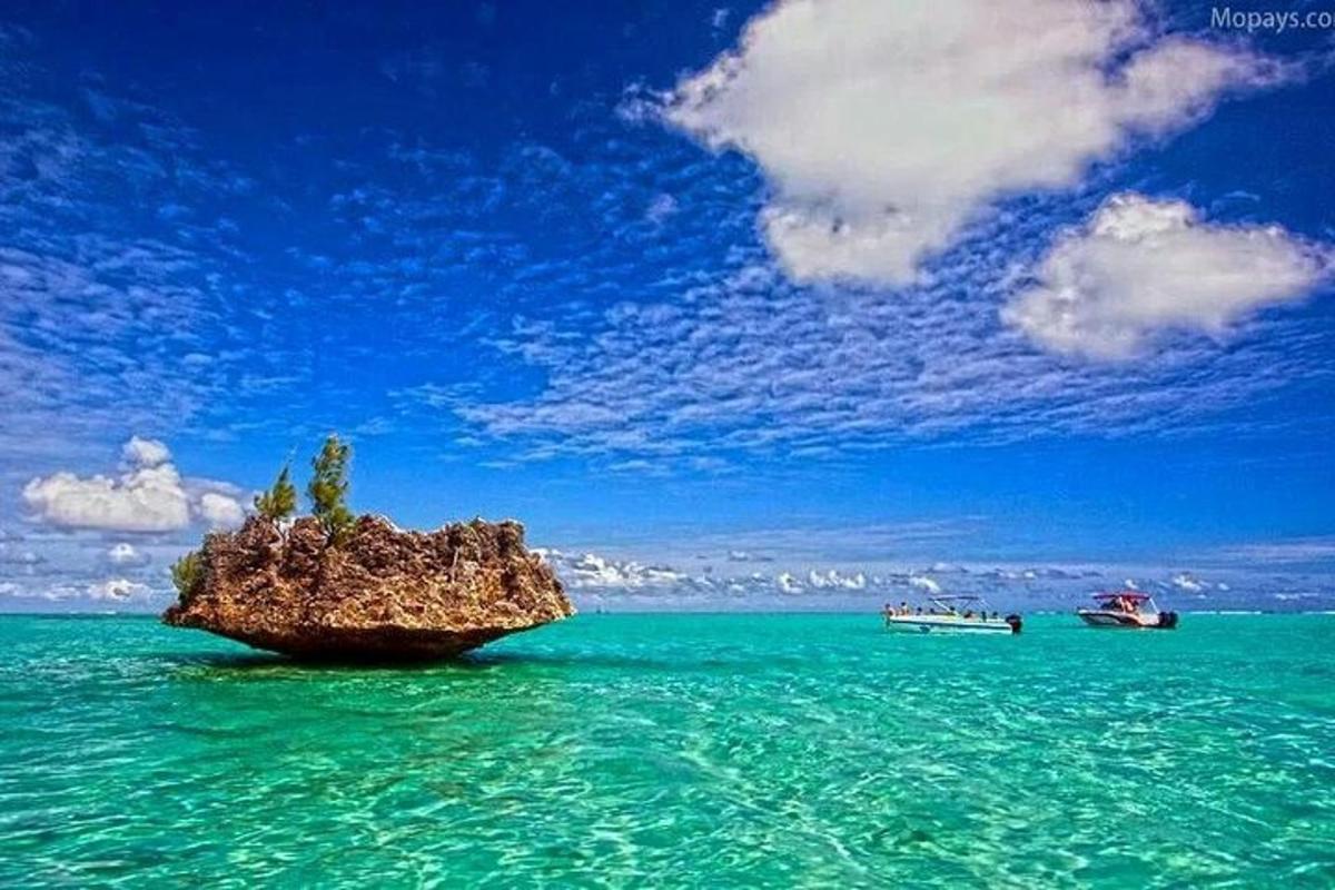 una roccia nell'acqua con due barche dentro