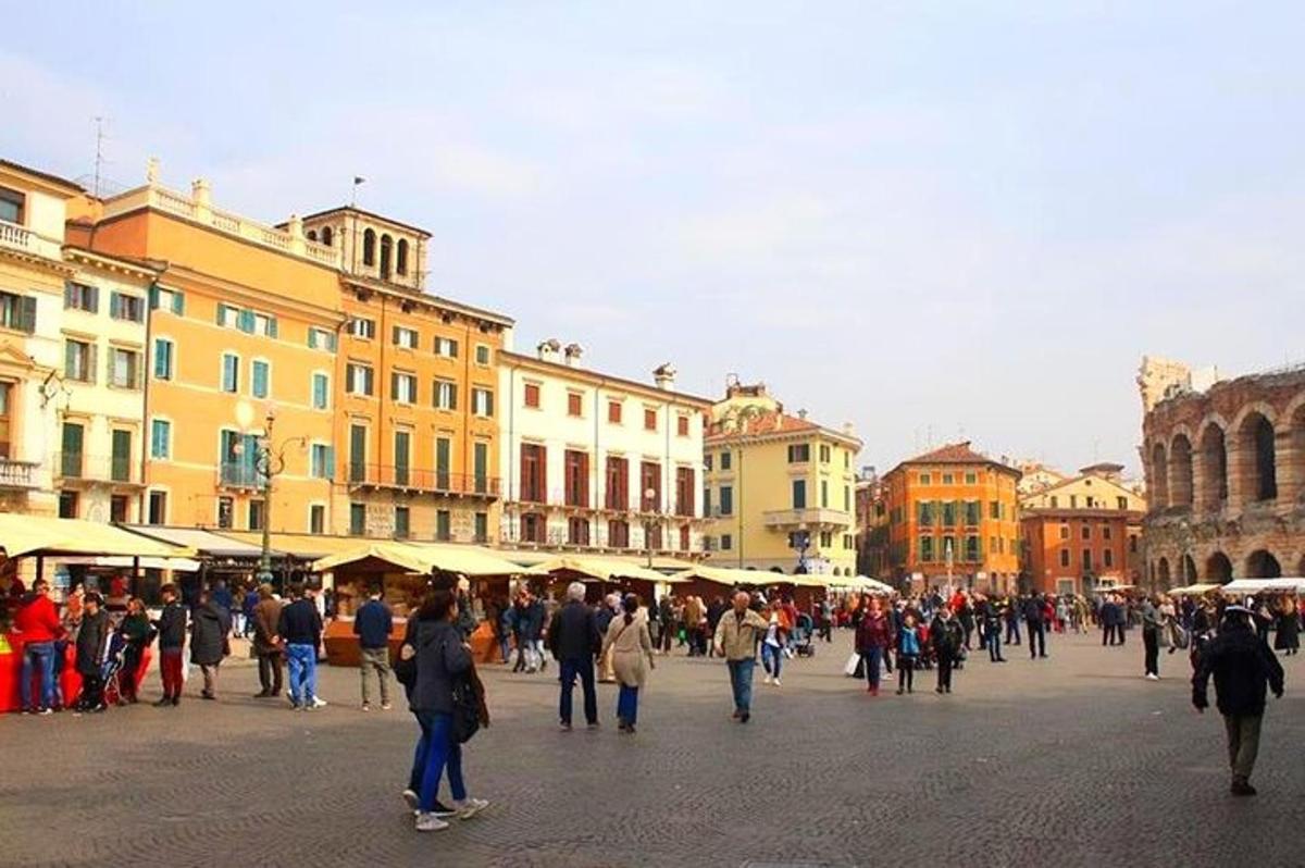 un gruppo di persone che camminano lungo una strada con edifici