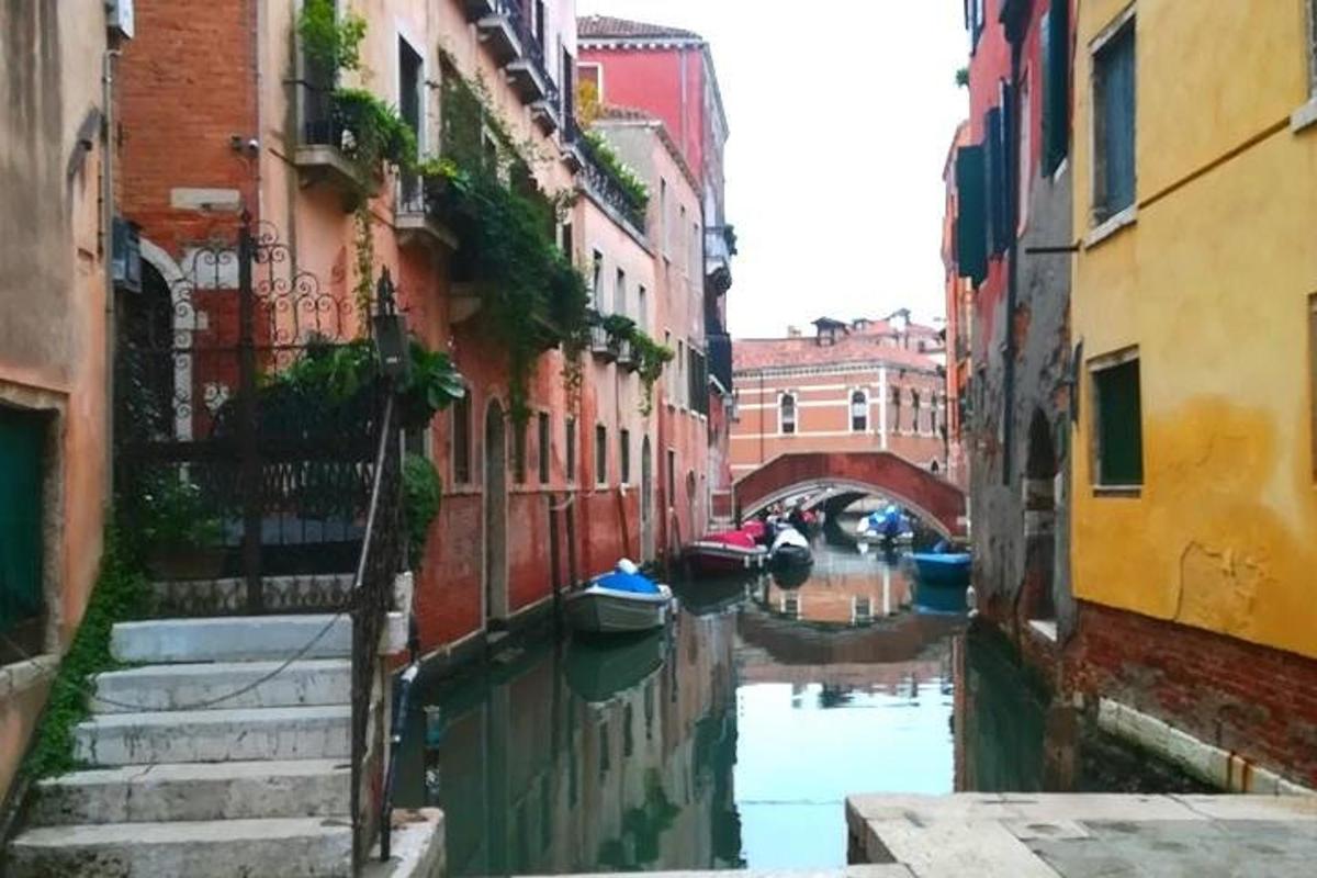 un canal entre deux bâtiments avec des bateaux dans l'eau