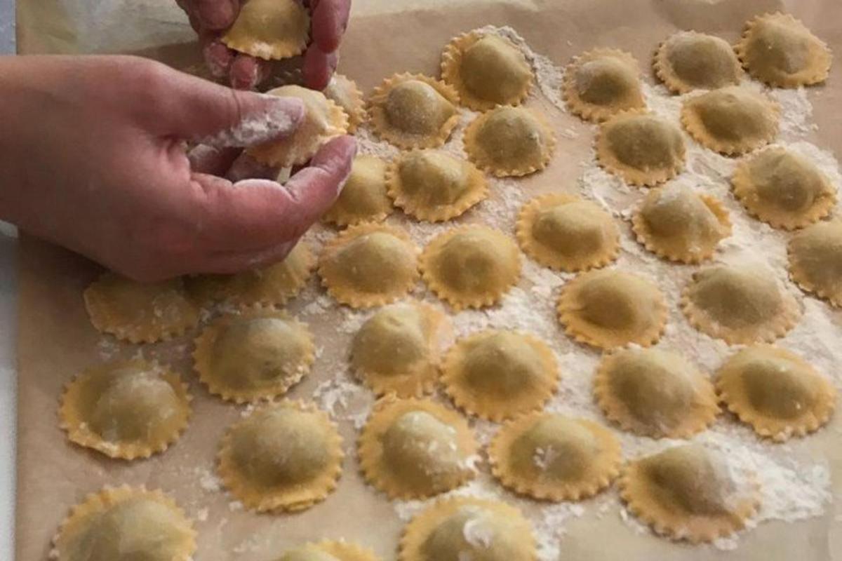 una persona tiene in mano un vassoio di pasta per biscotti