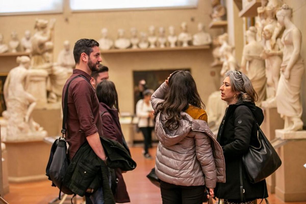 mga taong nakatayo sa isang museo na tumitingin sa mga estatwa