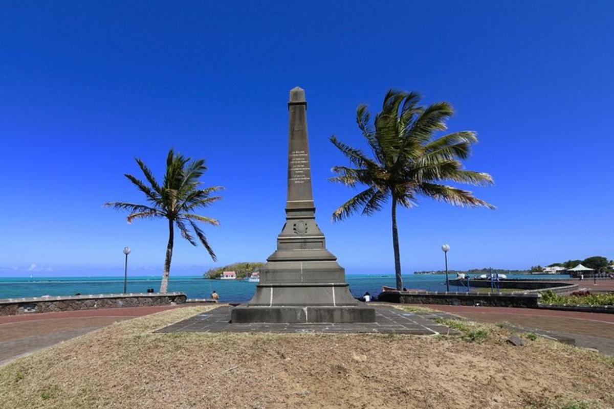 kahe palmipuuga rannas asuv monument