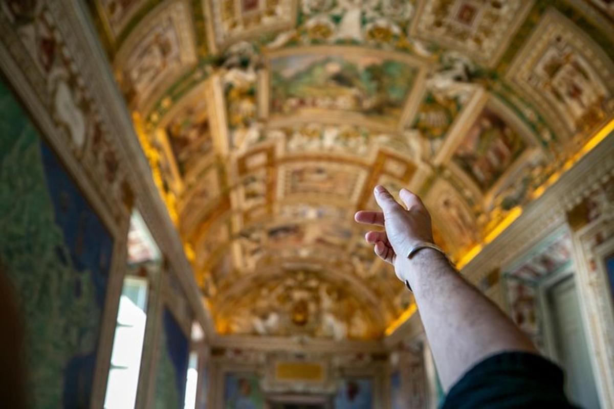 a persons hand reaching up to a ceiling with a painting