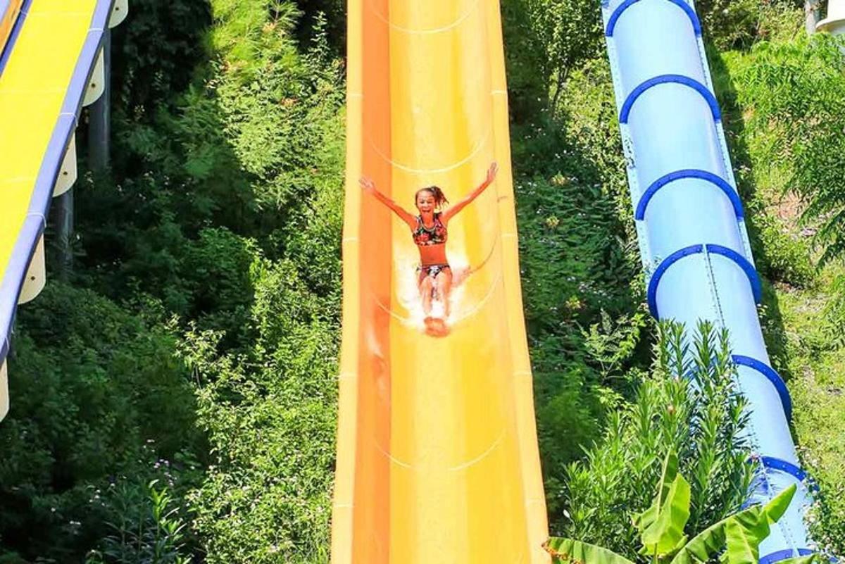 a woman riding a roller coaster on a water slide
