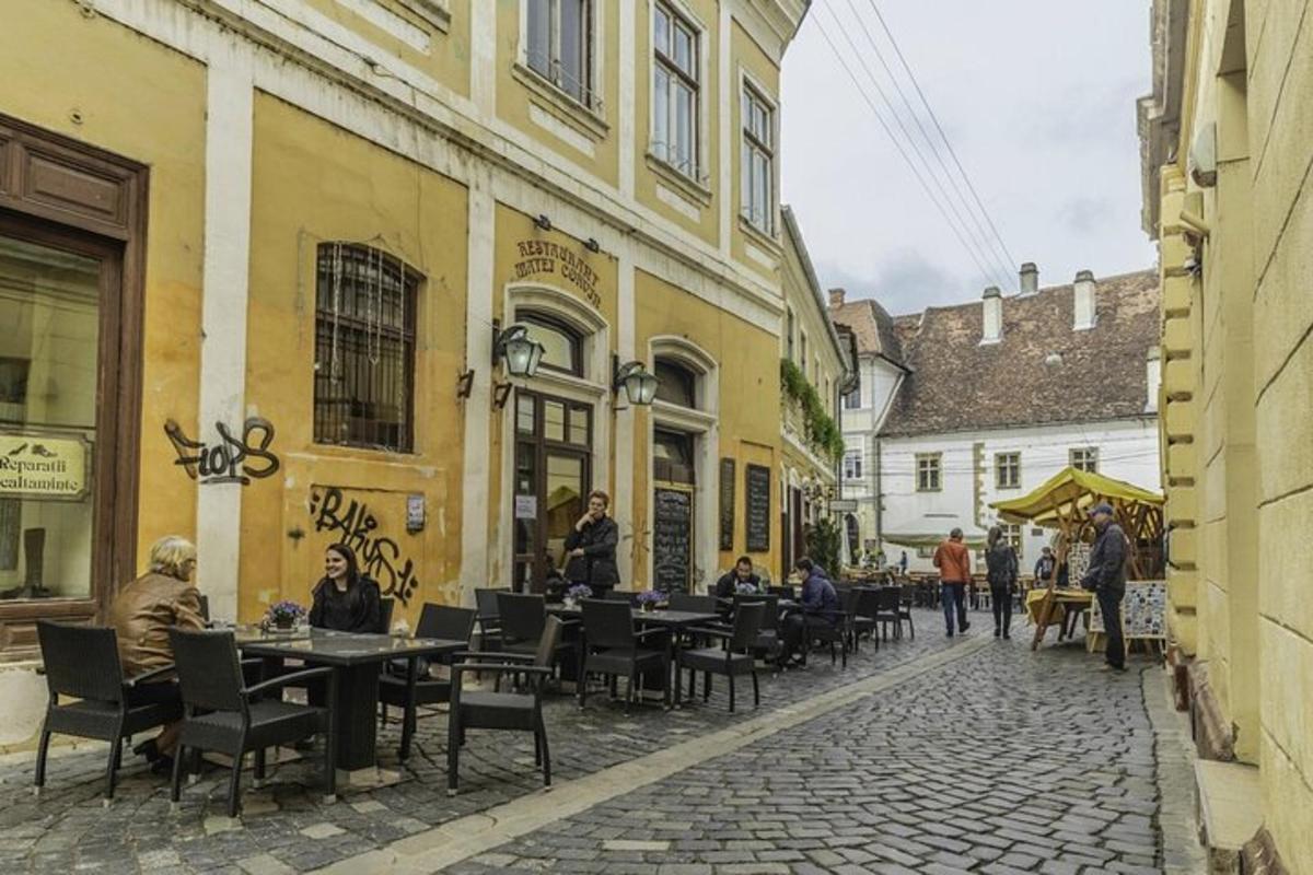 skupina lidí sedících u stolů na ulici