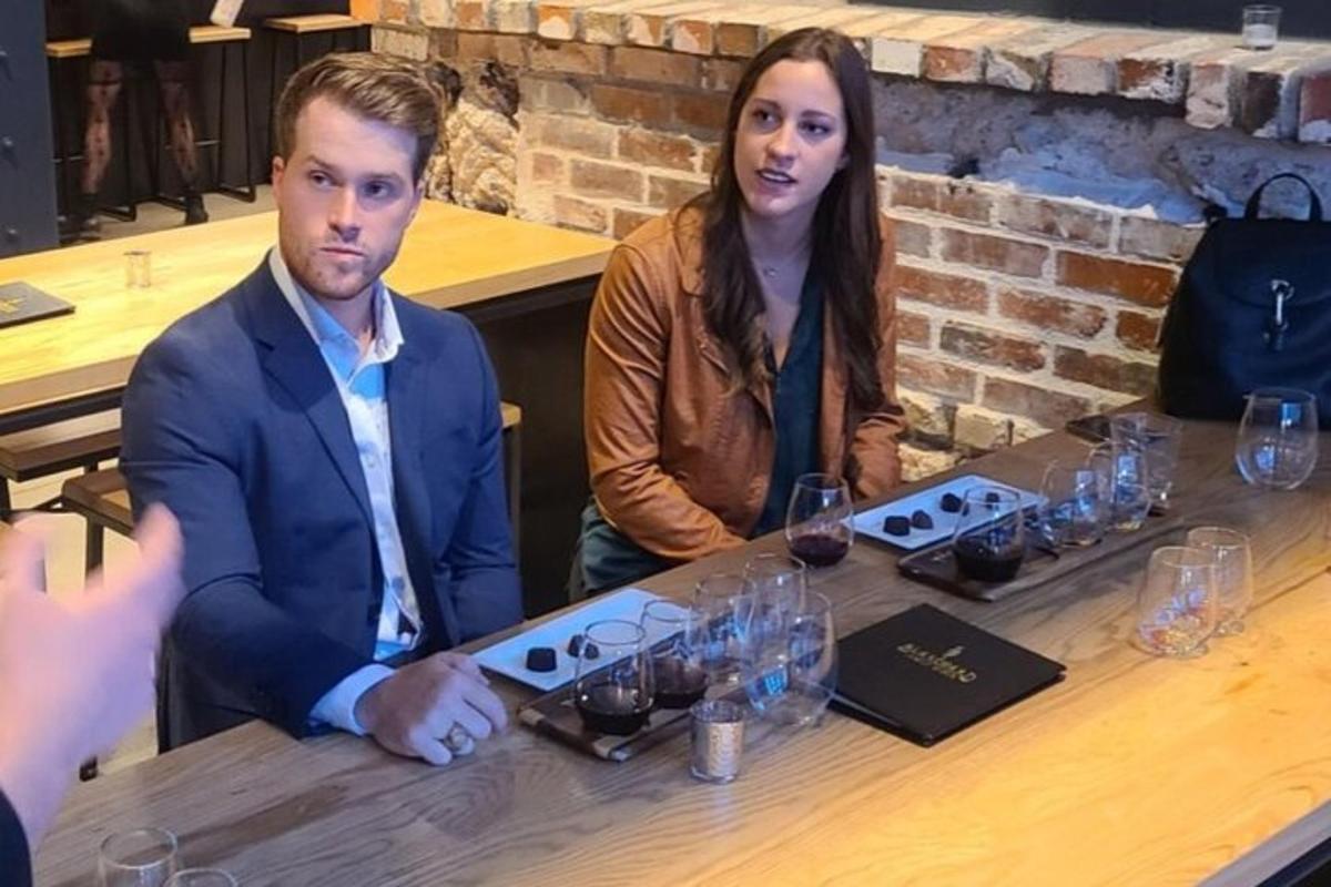 a man and a woman sitting at a table with wine glasses