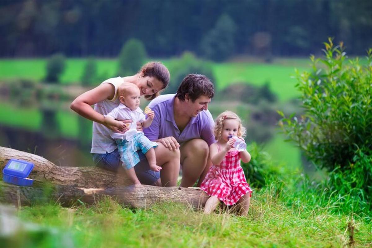 a family sitting on a log with two little girls