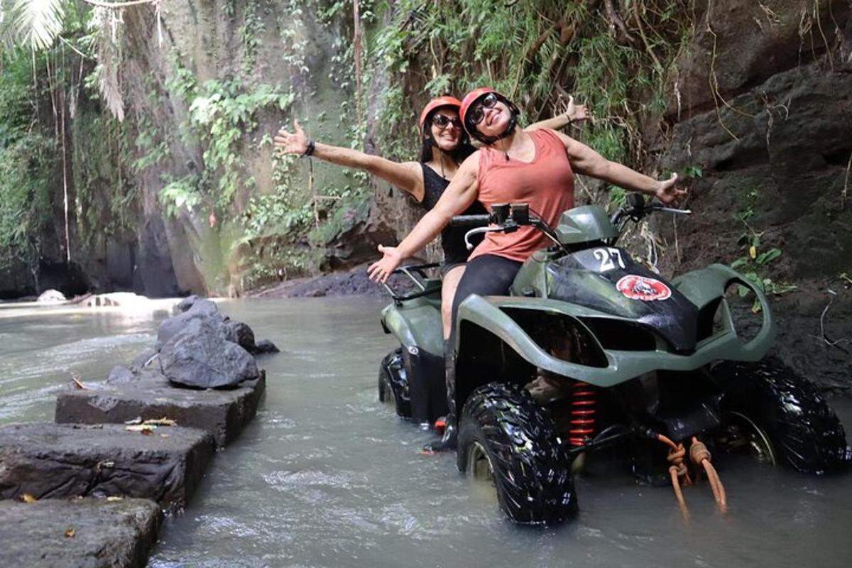 zwei Personen fahren auf einem Motorrad durch einen Fluss