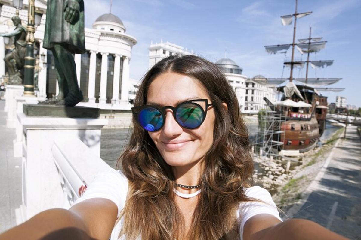 eine Frau mit Sonnenbrille und lächelt in die Kamera
