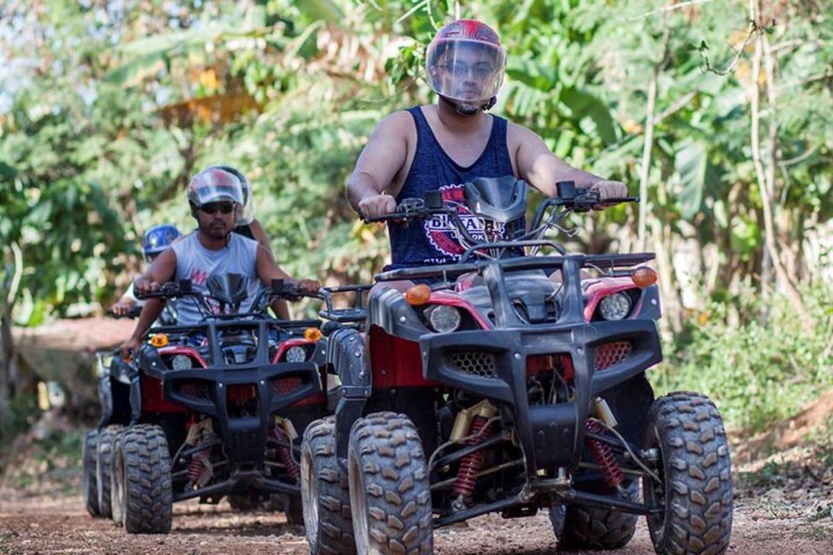 a man and a boy riding on atvs on a trail