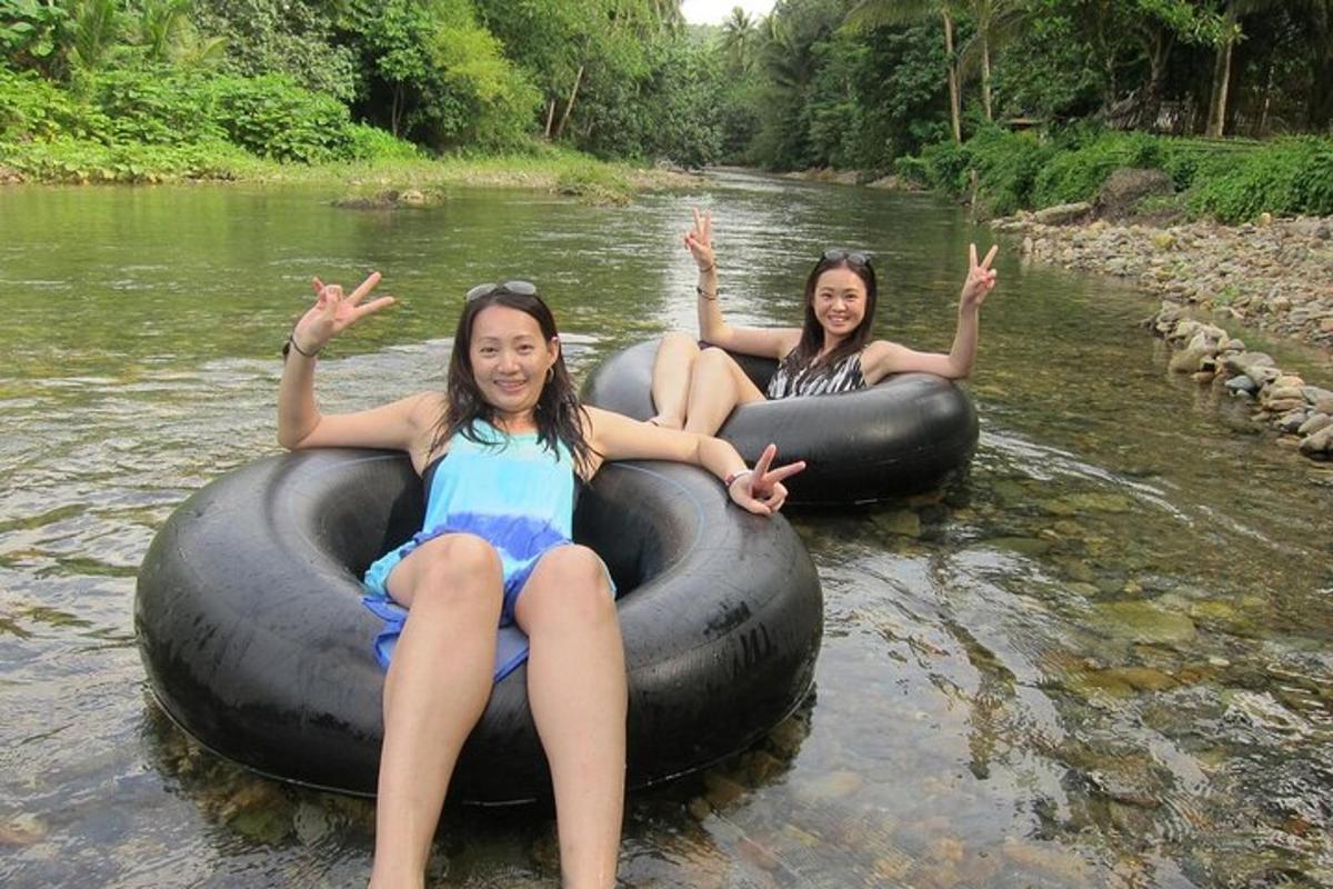 two girls are sitting on an inner tube in the water