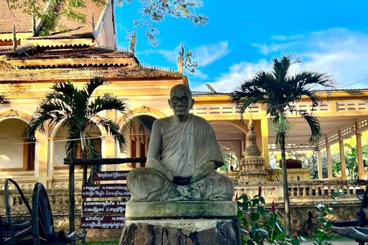 uma estátua de um homem sentado em frente a um prédio