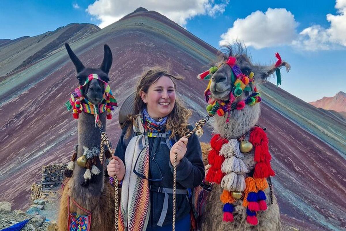 una donna in piedi accanto a due lama di fronte a una montagna