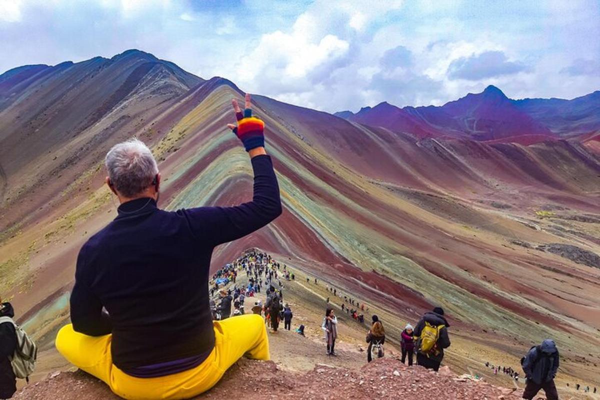 un uomo seduto a terra che guarda una montagna