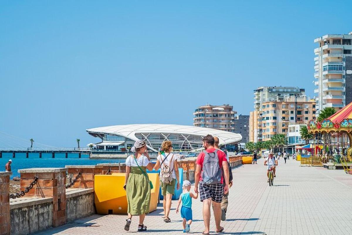 Μια οικογένεια περπατάει σε ένα πεζοδρόμιο μπροστά από ένα στάδιο