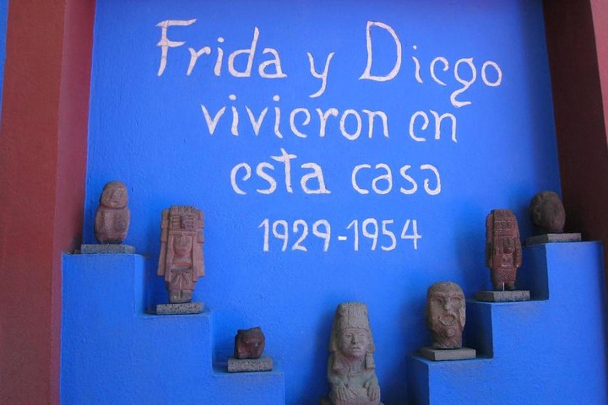a blue wall with statues on display in a museum
