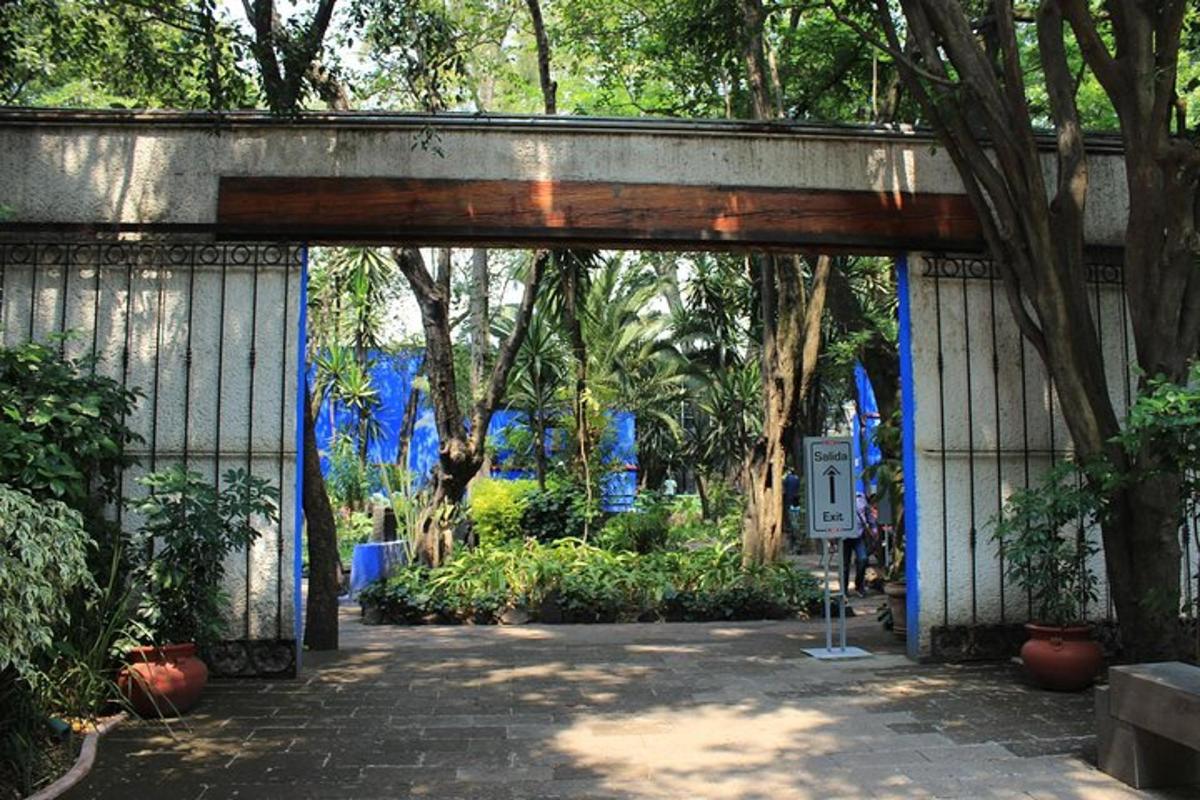 an entrance to a garden with blue walls and trees