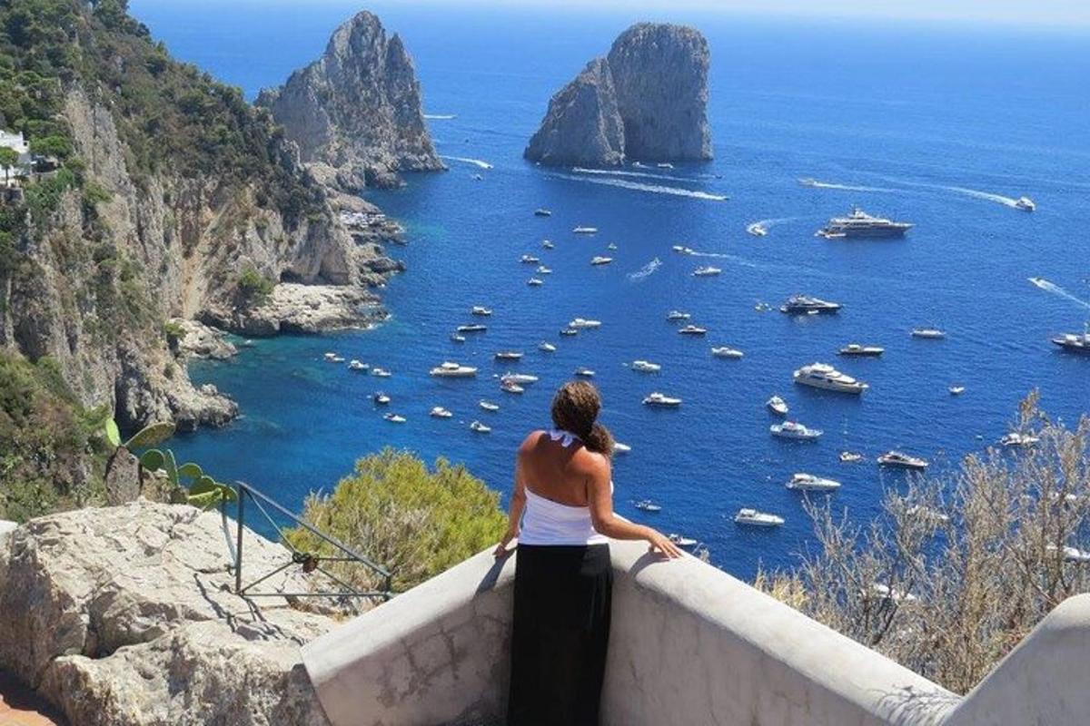žena stojící na římse a dívající se na oceán