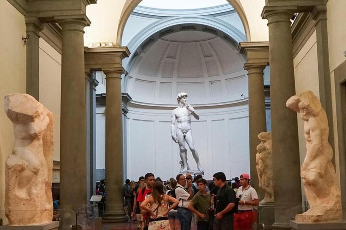 Un grupo de personas de pie frente a una estatua en un museo.